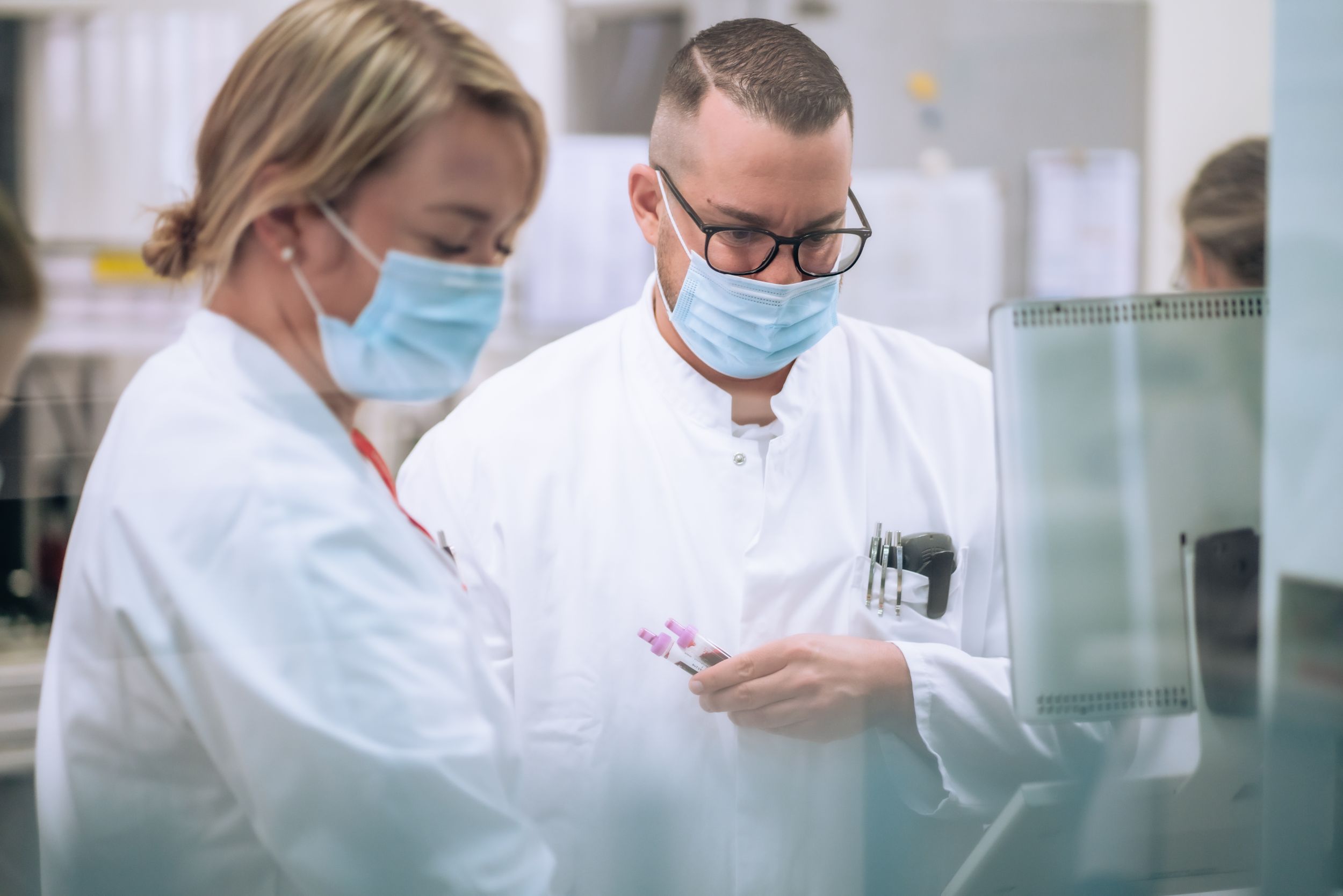 Zwei Mitarbeitende aus der Labormedizin begutachten ein Gerät