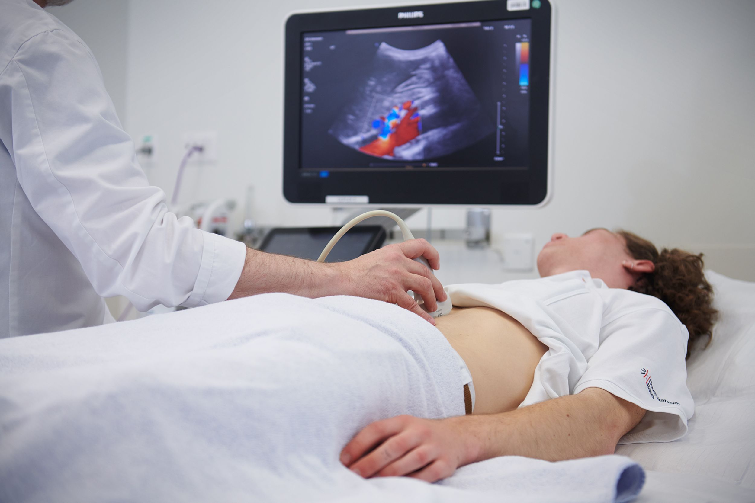Arzt führt bei Patient Ultraschall-Untersuchung durch