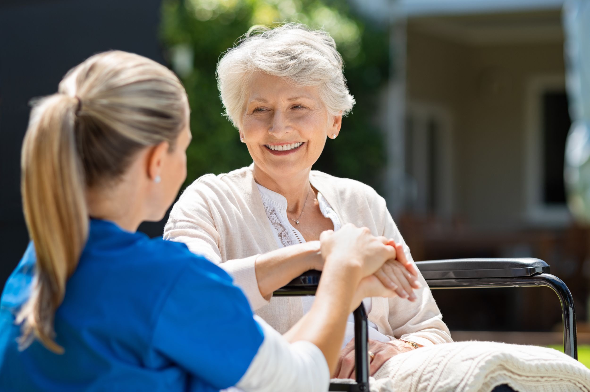 Patientin mit Pflegerin im Garten