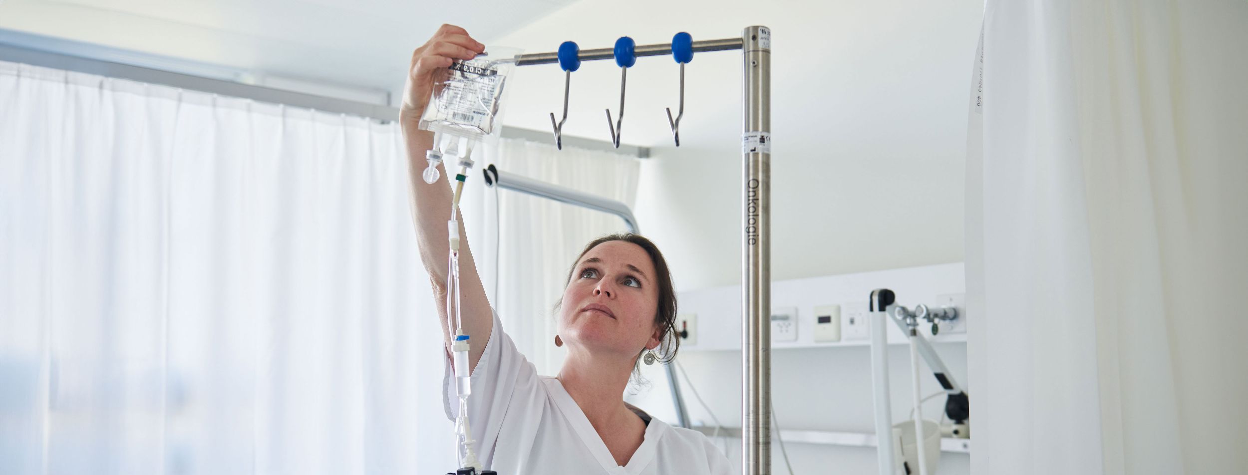 Une infirmière accroche un traitement contre le cancer pour un patient