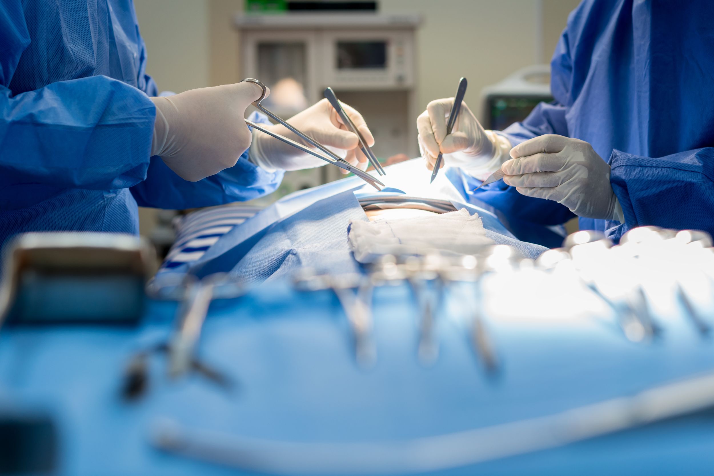 Nahaufnahme eines Ärzteteams, das bei einer Operation eine Wunde zusammennäht