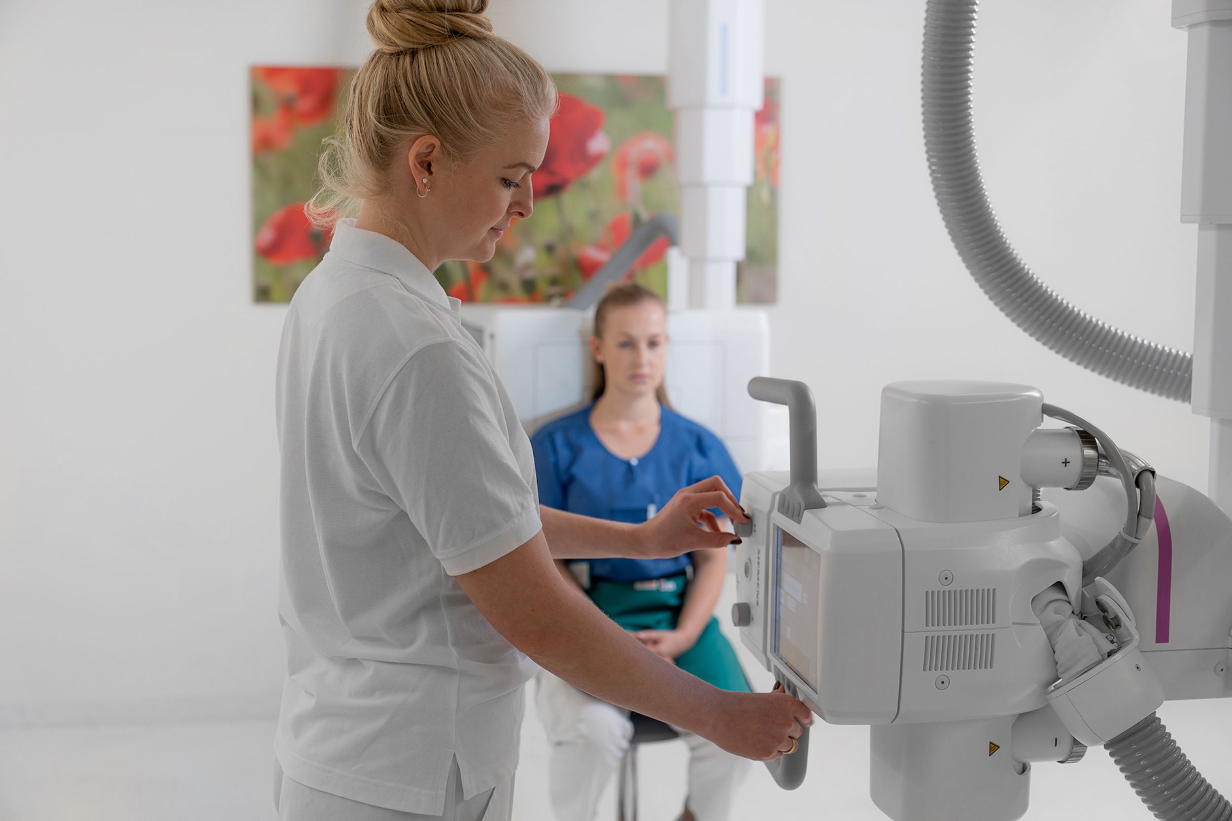 Mitarbeiterin der Radiologie bereitet Bestrahlung von Patientin vor