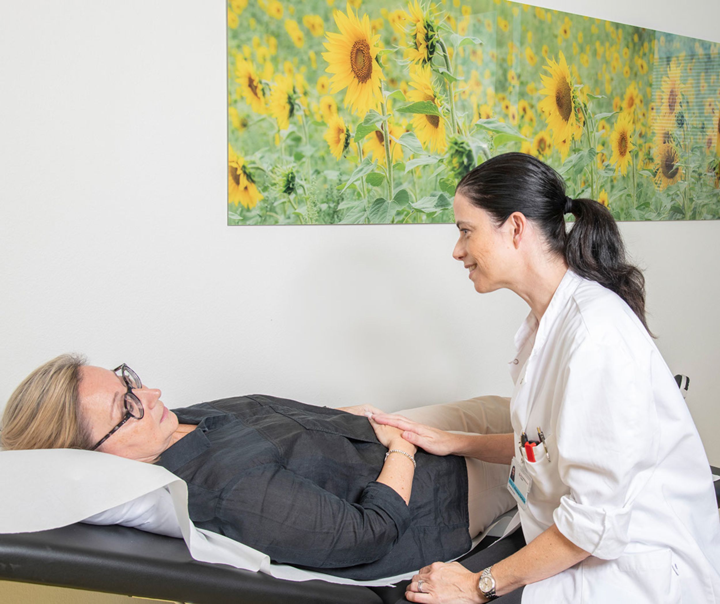 Ärztin untersucht liegende Patientin