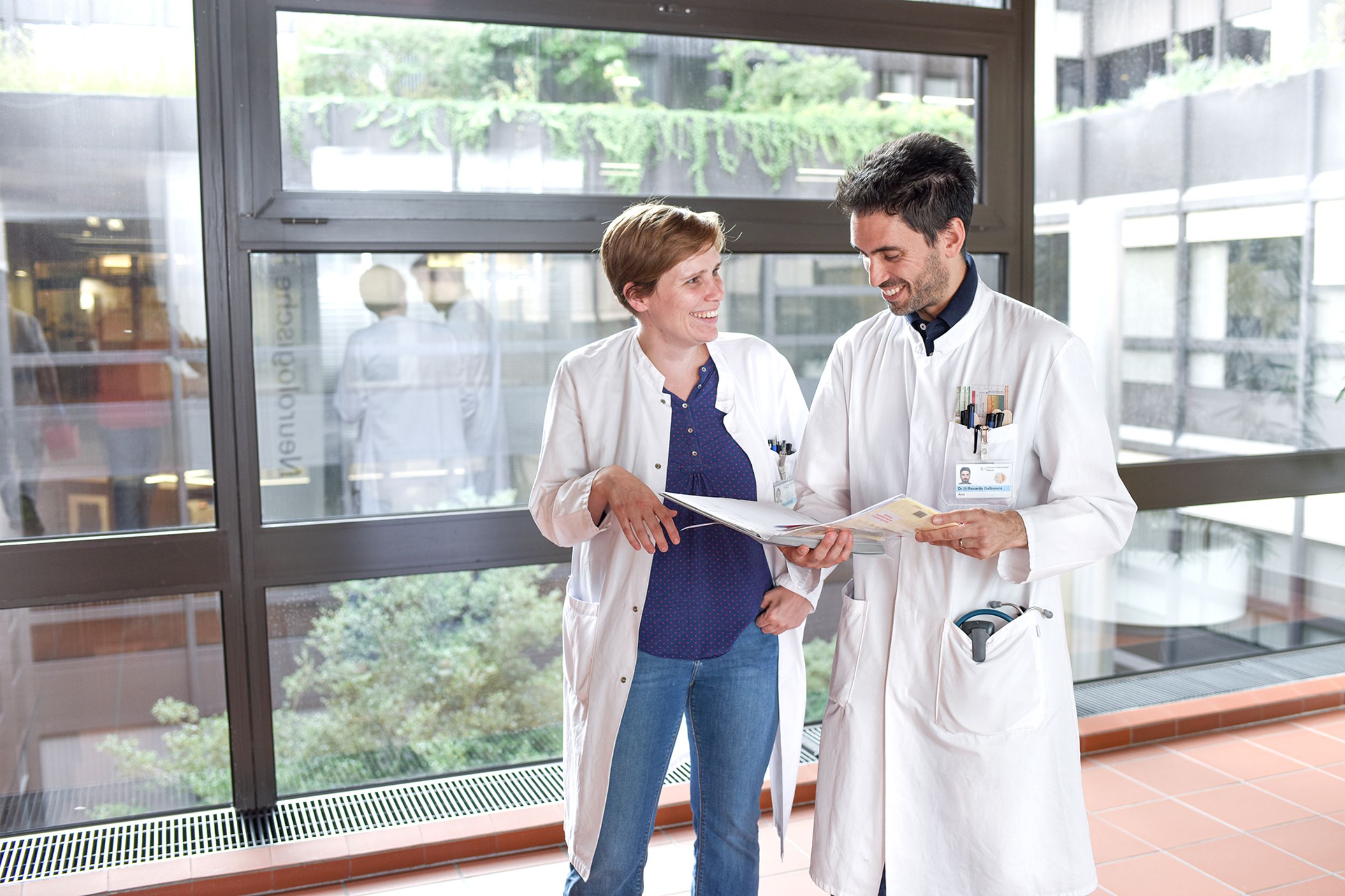 Arzt und Ärztin im Gespräch auf Gang vor der Neurologischen Poliklinik