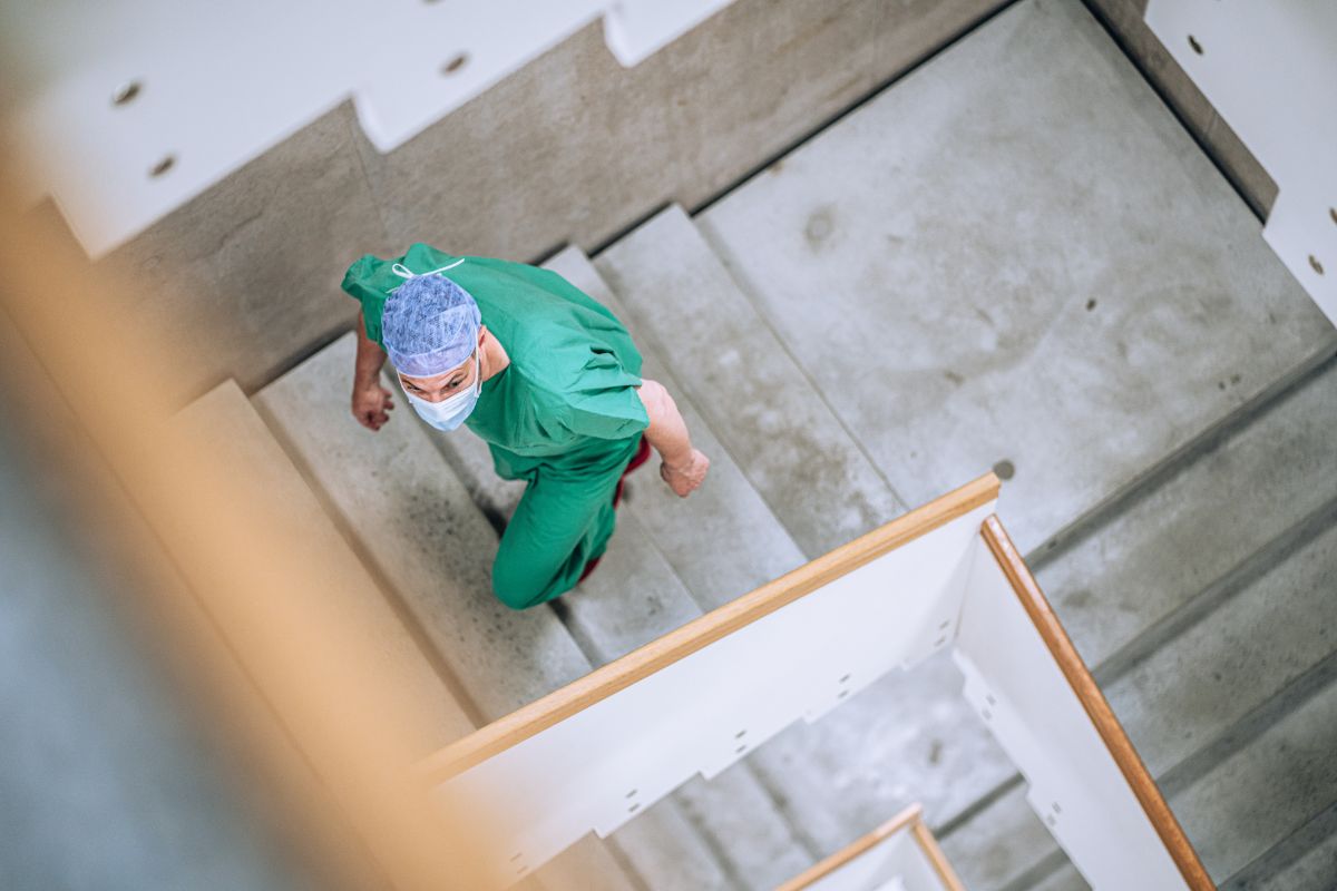 Un médecin en tenue d'opération monte les escaliers