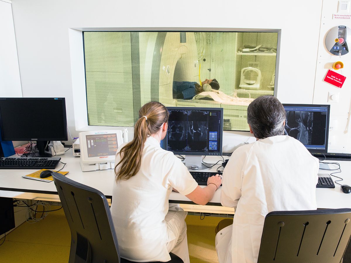 Zwei Radiologen betrachten einen Patienten im MRI.