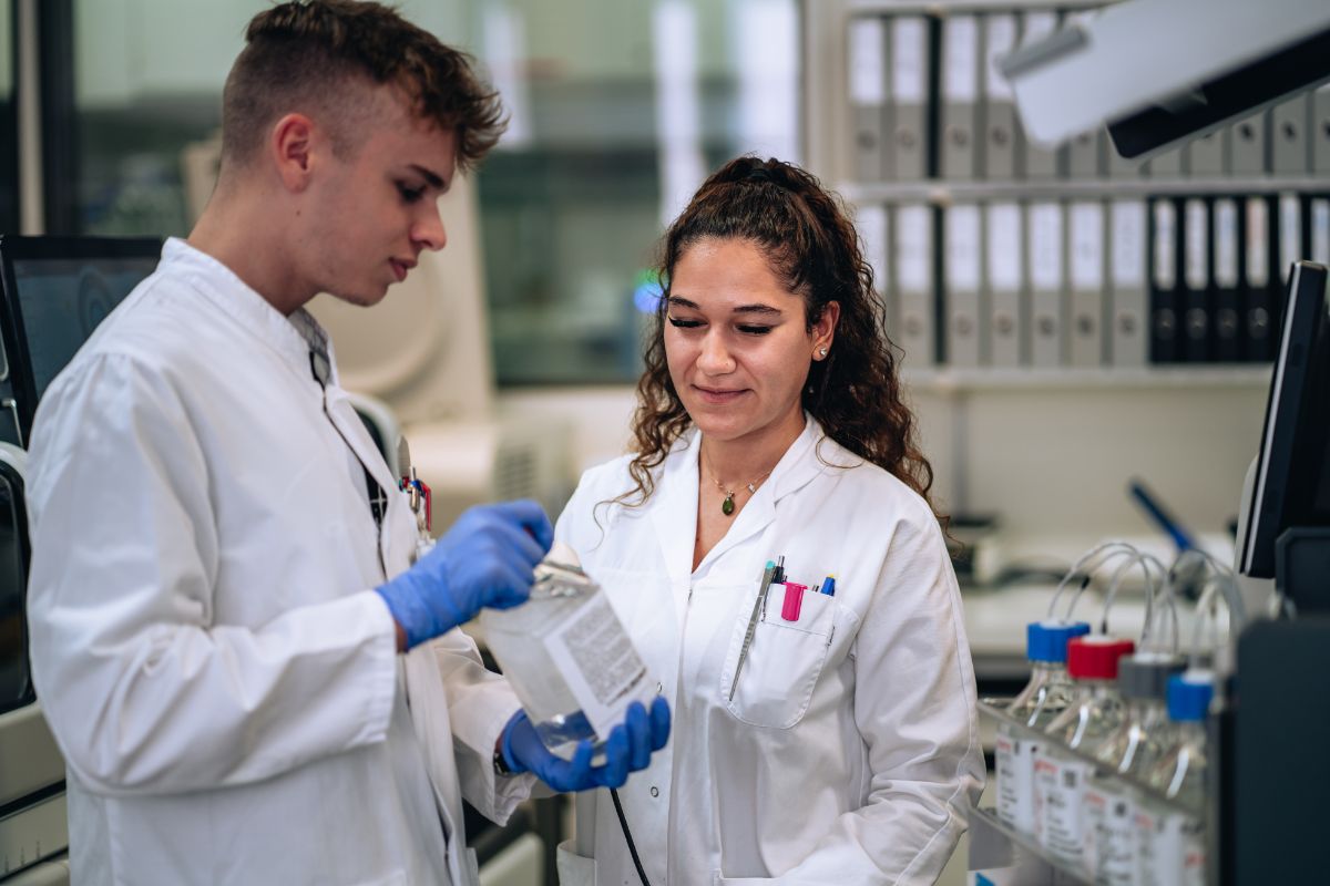 Une laborantine et un laborantin en formation parlent d'un équipement médical