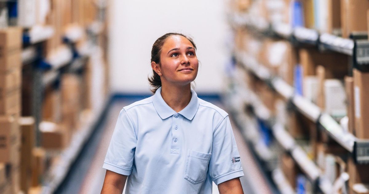 Logistikerin in Ausbildung läuft durchs Lager